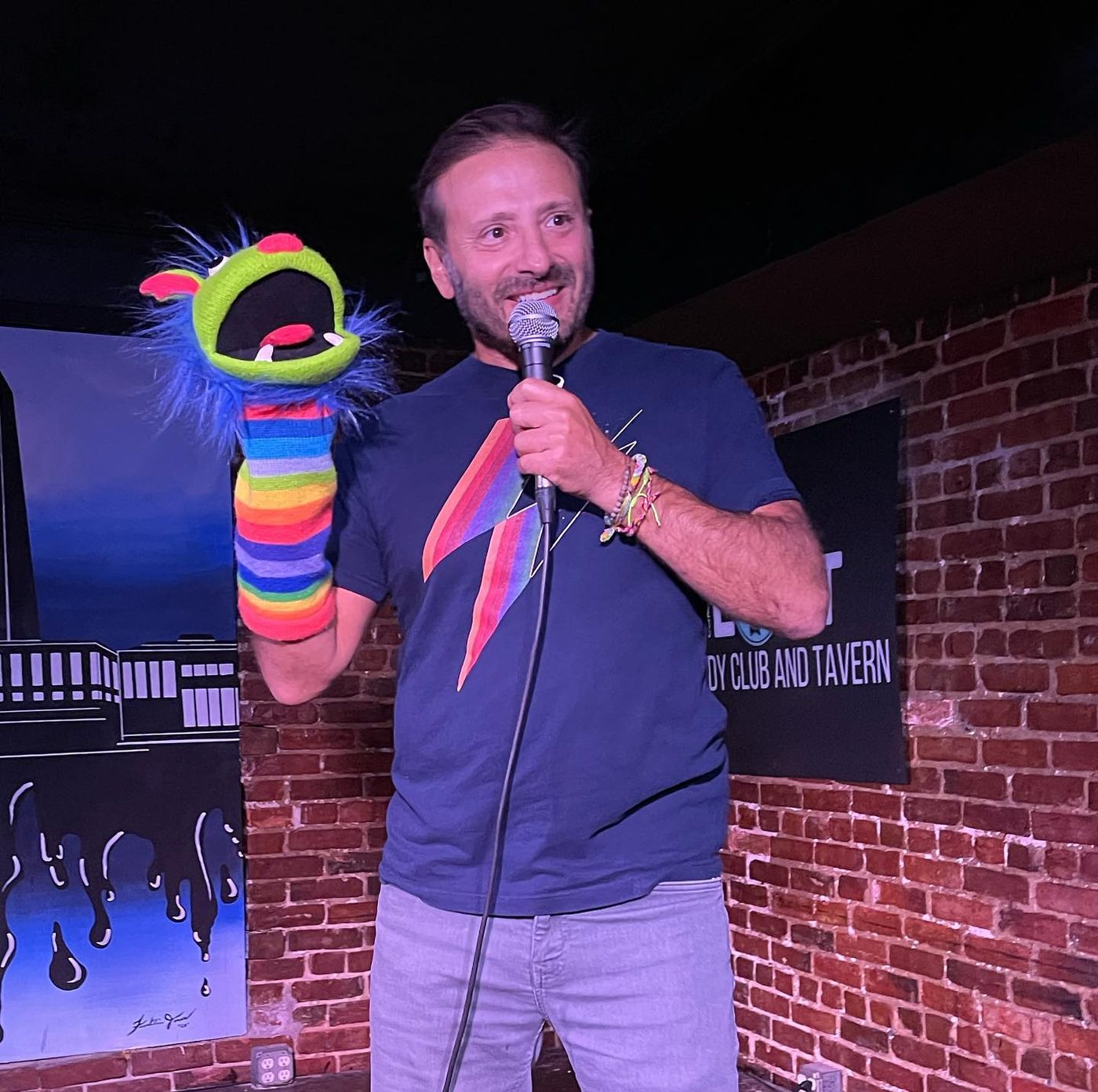 Yanik at an open mic with a sock puppet